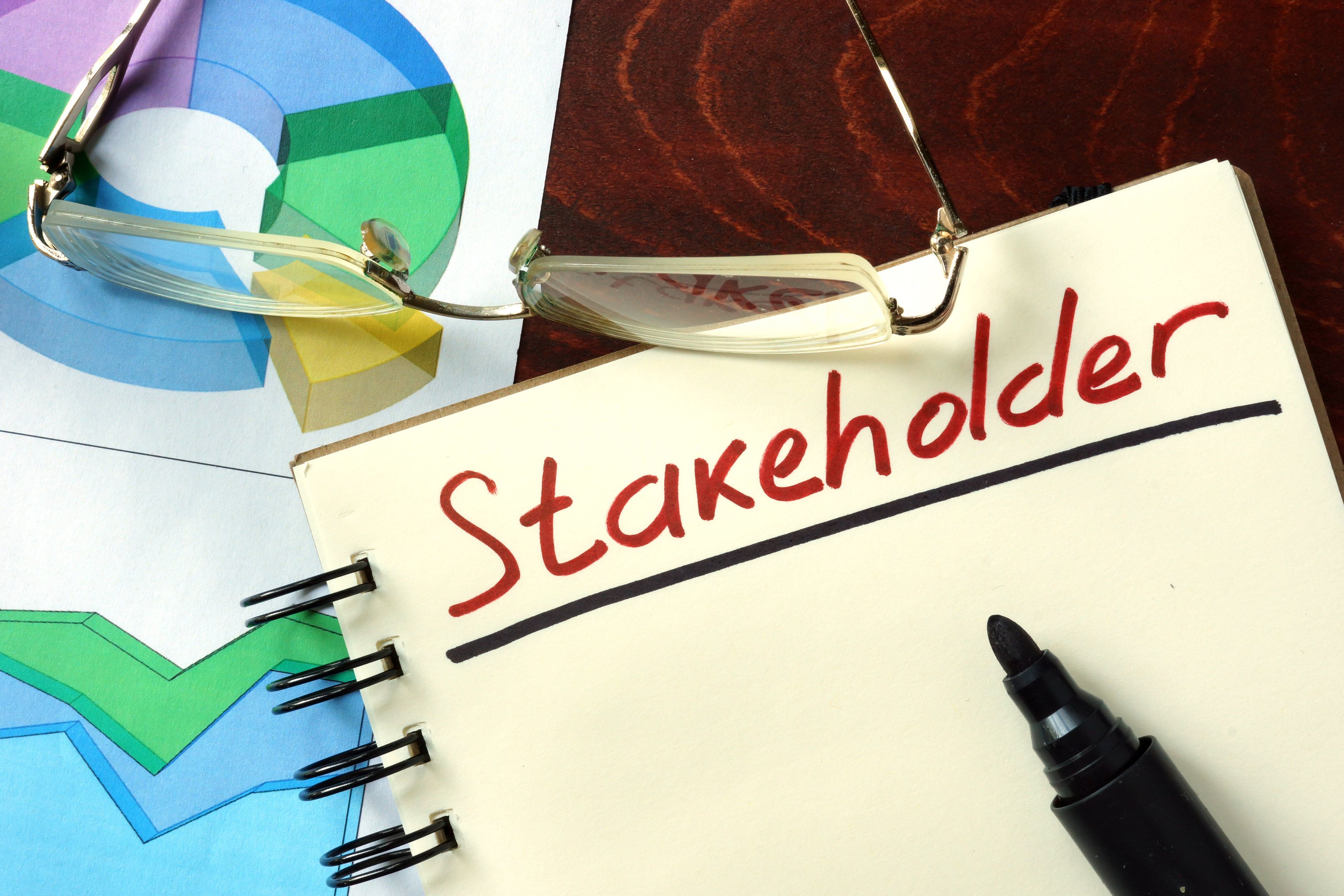 Notepad with Stakeholder on the wooden table.